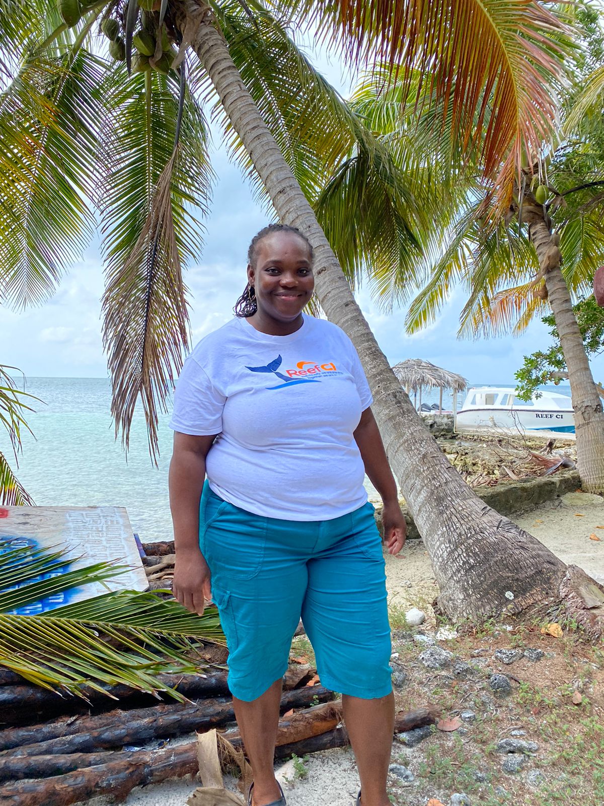 a person standing in front of a palm tree and water