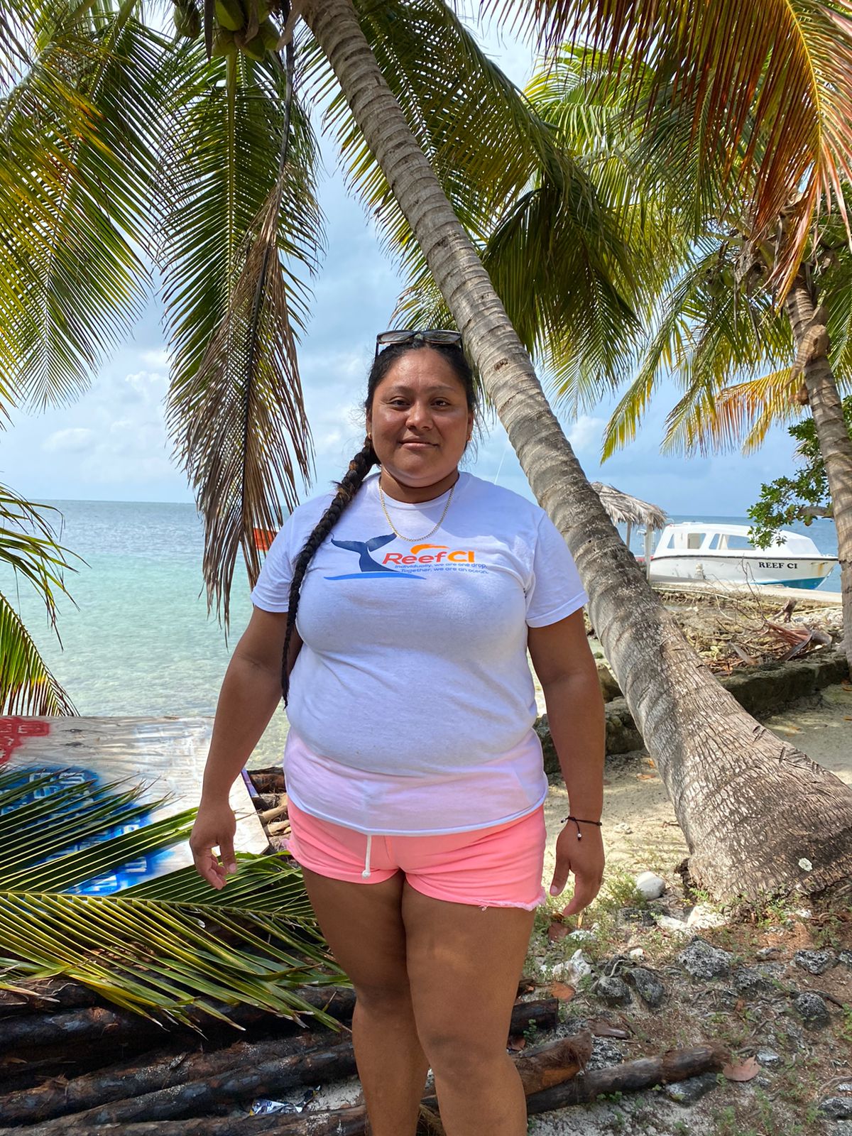 a person standing next to a palm tree next to a body of water