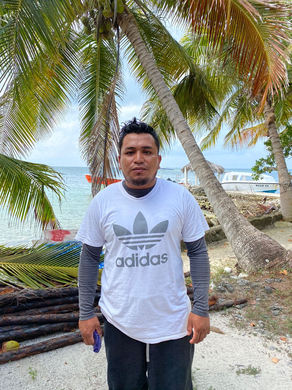 a man standing next to a palm tree